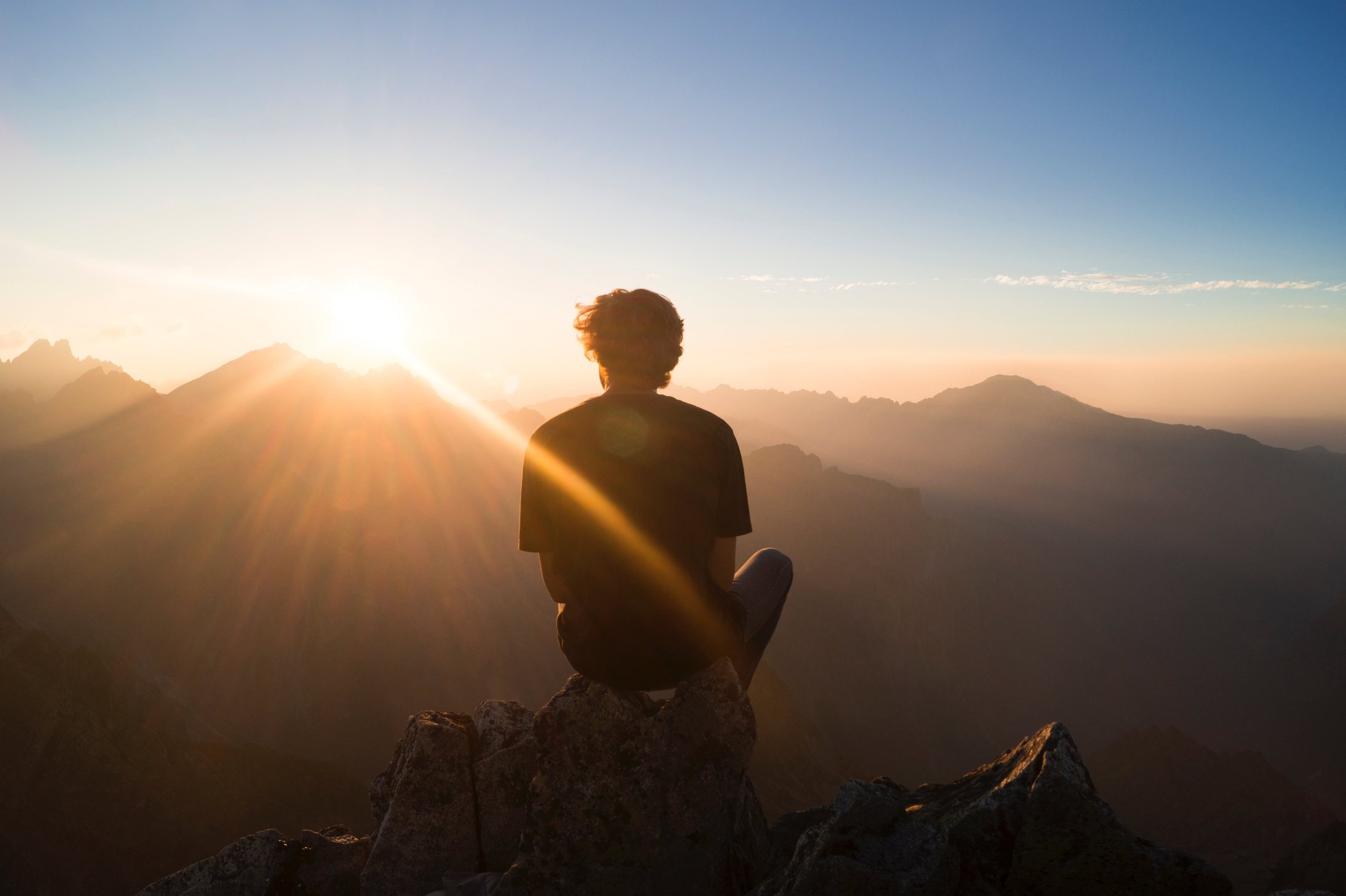 Man sitting on the mountain top at dawn 